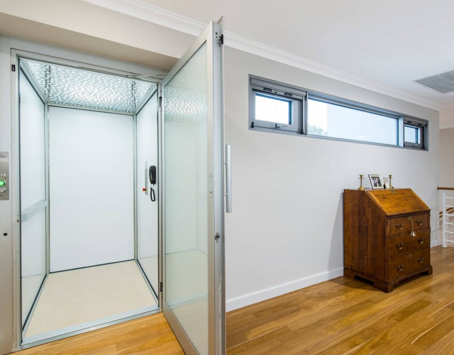 Residential lift with a glass door integrated into the hallway of a two-storey home