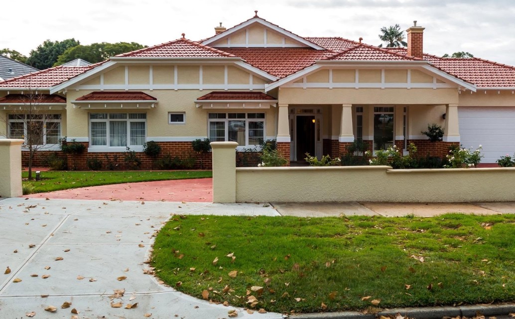 Restored Federation bungalow with terracotta tiled roof, red brick base and timber gable fretwork