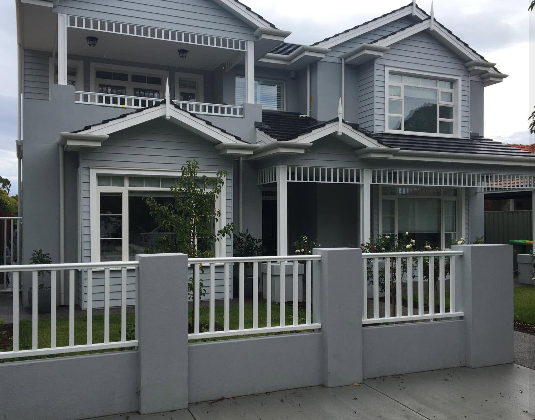Grey weatherboard second-storey addition on a Perth family home, with gabled dormers and a white balustraded verandah