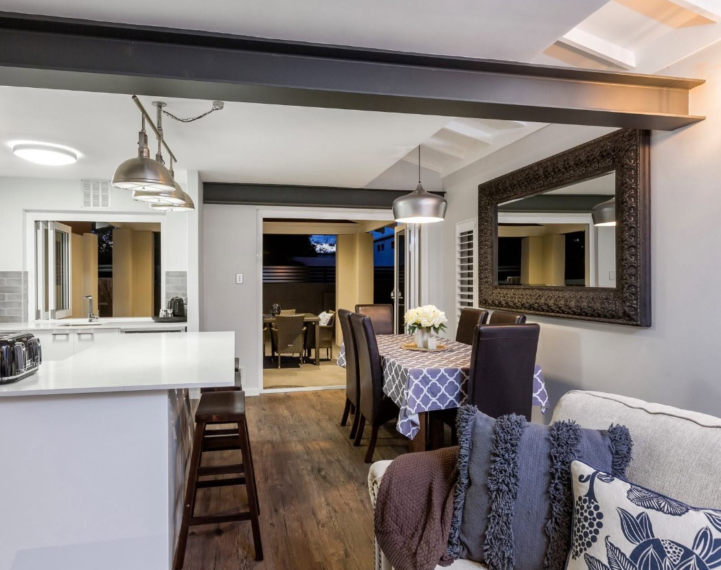 Covered alfresco extension with a timber-lined ceiling, opening off the rear of an existing home