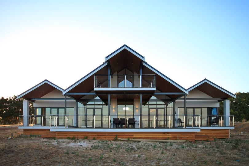 Second-storey addition with balcony and ocean glimpses over suburban rooftops